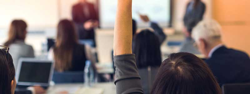 Woman raising her hand during a presentation